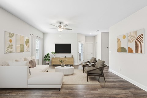 a living room with white furniture and a ceiling fan